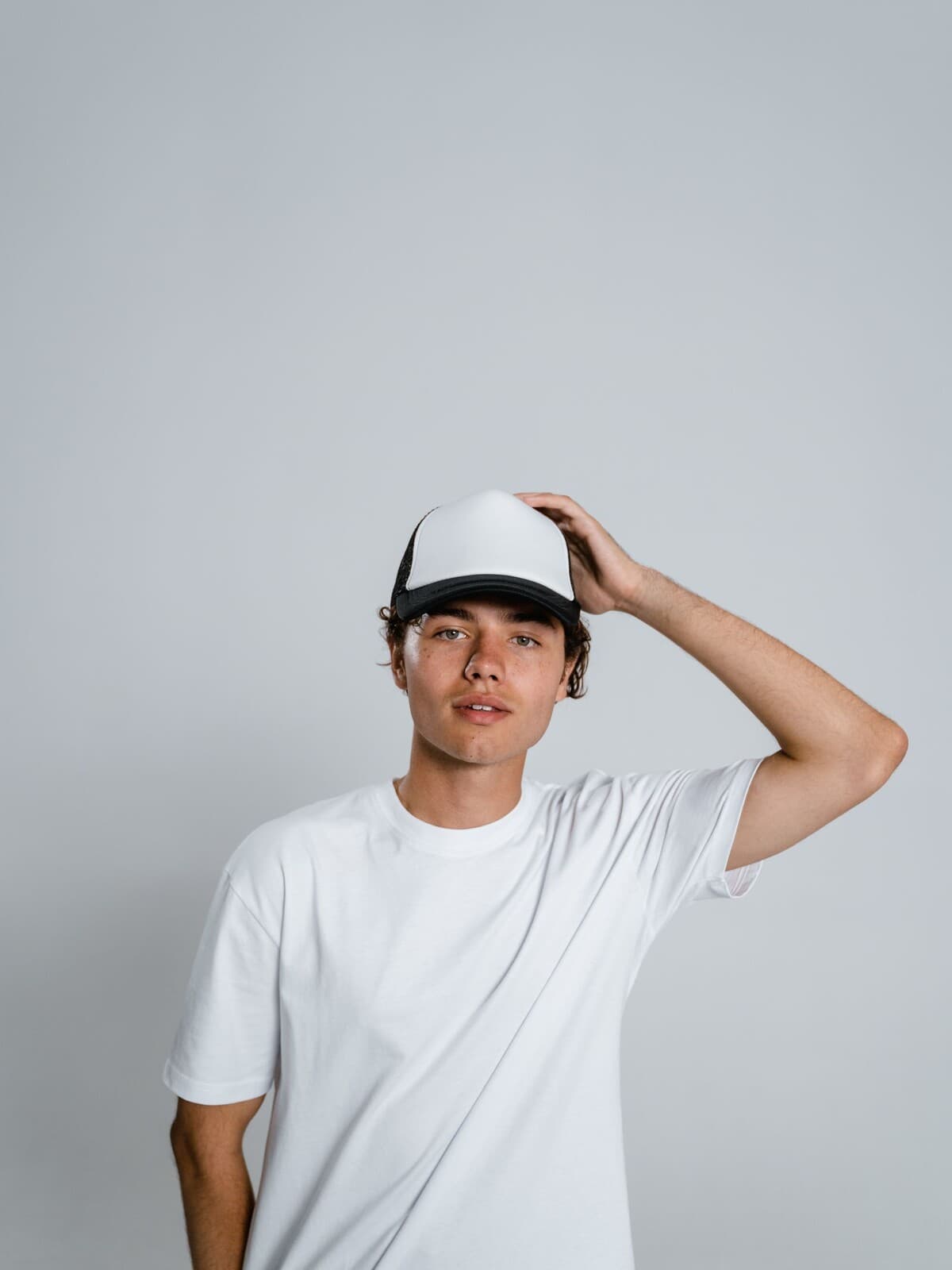 Man wearing a blank trucker cap and white t-shirt
